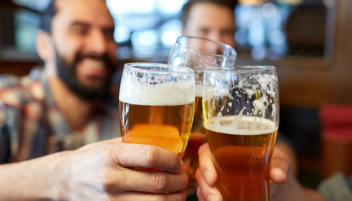 Friend cheers tap beer glasses at Cinders Charcoal Grill Appleton Wisconsin Restaurant and Bar